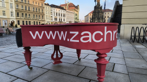 Za červenými piany v ulicích Olomouce stojí filharmonici